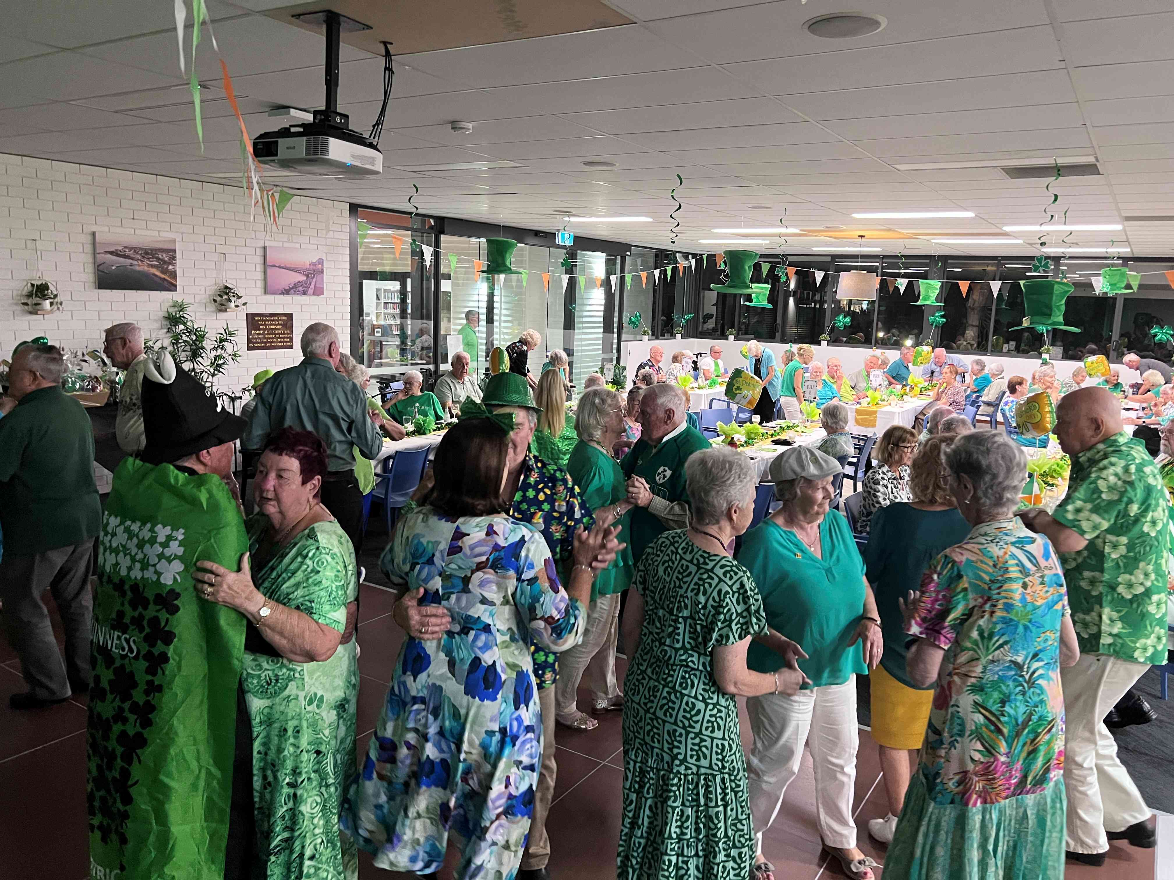 Seniors enjoying dancing at a lively St Patrick's Day event.